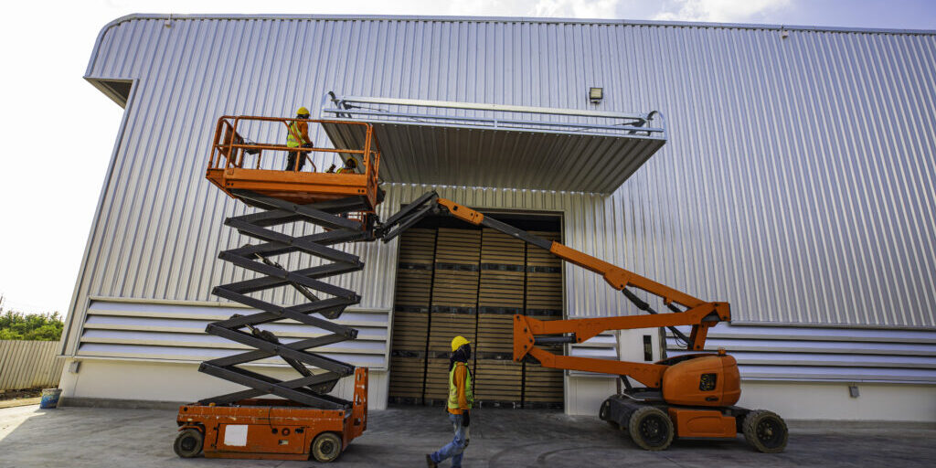 Workers working on the construction site of the new factory industry for boom lift roof